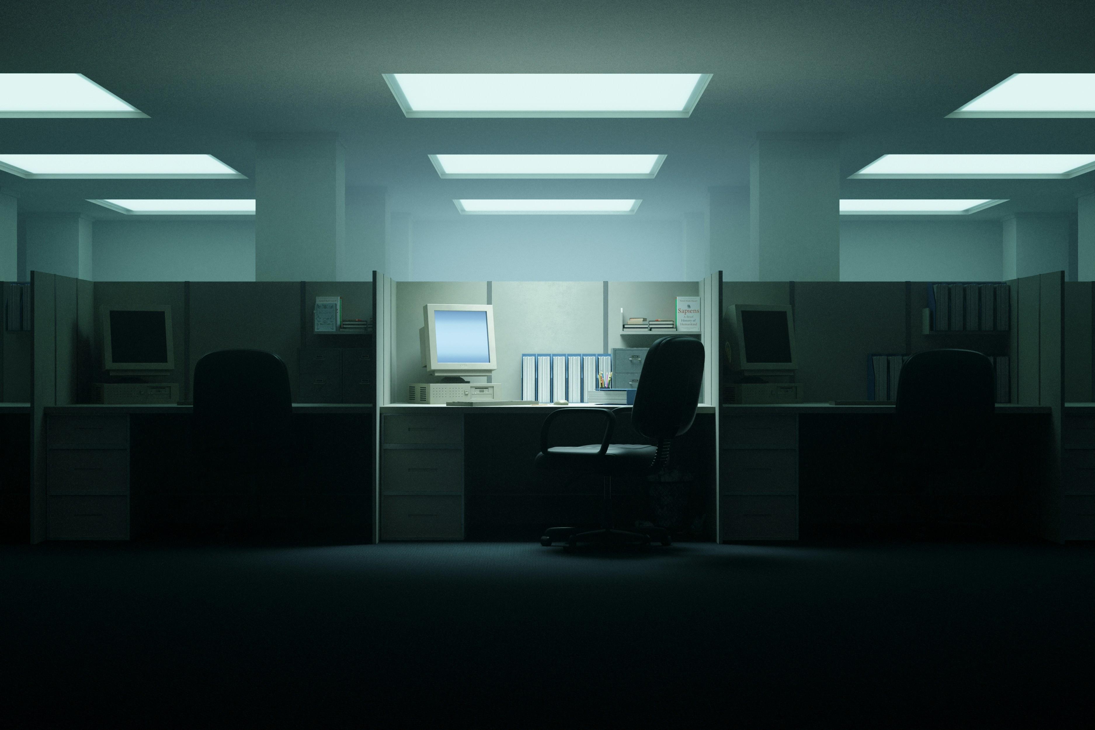 An illuminated workstation in a quiet office with vintage computers